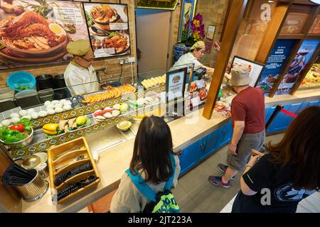 SINGAPUR - 20. JANUAR 2020: Ein Mann, der in einem Food Court in den Shoppes at Marina Bay Sands Essen bestellt Stockfoto