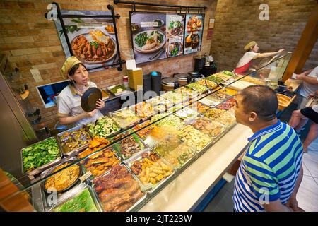 SINGAPUR - 20. JANUAR 2020: Ein Mann, der in einem Food Court in den Shoppes at Marina Bay Sands Essen bestellt Stockfoto