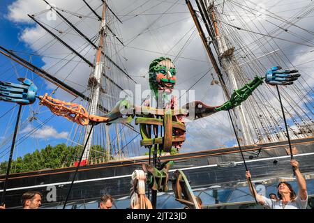 London, Großbritannien. 27. August 2022. Out of the Deep Blue begeistern die Besucher des Greenwich and Docklands International Festivals mit ihrer riesigen Puppentheater bei schönem, heißem Sonnenschein. Ein magisches und interaktives Abenteuer mit Eko, der 13ft Meter hohen Sea Giant Puppe, die aus der Tiefe hervorgegangen ist, um Publikum jeden Alters in eine andere Welt zu transportieren. Die Performance findet vor dem Hintergrund der Cutty Sark und der Themse statt, wo die Kreatur einen Spaziergang um den alten Teeschneider macht und mit dem Publikum interagiert. Kredit: Imageplotter/Alamy Live Nachrichten Stockfoto