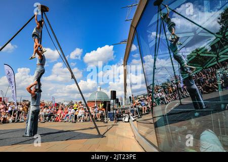 London, Großbritannien. 27. August 2022. Sisyphus treten auf der spektakulären Outdoor-Bühne vor der Cutty Sark beim Greenwich and Docklands International Festival auf. Drei unglaubliche Zirkuskünstler kombinieren ihre Fähigkeiten im Fliegen, Partnerakrobatik und Gurte, um die pure Freude zu feiern, die ihr Publikum heute bei schönem Sonnenschein fesselt. Kredit: Imageplotter/Alamy Live Nachrichten Stockfoto