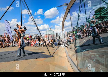 London, Großbritannien. 27. August 2022. Sisyphus treten auf der spektakulären Outdoor-Bühne vor der Cutty Sark beim Greenwich and Docklands International Festival auf. Drei unglaubliche Zirkuskünstler kombinieren ihre Fähigkeiten im Fliegen, Partnerakrobatik und Gurte, um die pure Freude zu feiern, die ihr Publikum heute bei schönem Sonnenschein fesselt. Kredit: Imageplotter/Alamy Live Nachrichten Stockfoto