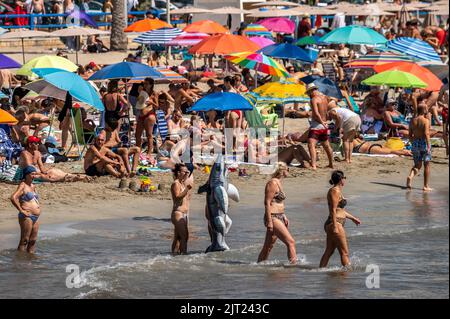 Alicante, Spanien. 27. August 2022. Der Strand El Postiguet ist an einem heißen Sommertag überfüllt, während viele Touristen und Einheimische sich sonnen und abkühlen. Das gesamte touristische Angebot in der Provinz Alicante hat die Belegungsdaten vor der Pandemie wiederhergestellt, wobei Touristenwohnungen und Hotels während eines Teils des Sommers eine Belegung von fast 100 % verzeichnen. Quelle: Marcos del Mazo/Alamy Live News Stockfoto