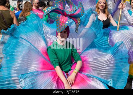 Manchester Pride Parade. Teilnehmer in blauem Blumenkostüm. Themenmarsch für den Frieden. Stockfoto