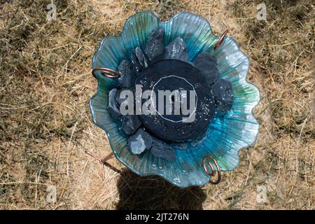 Blaues und grünes Vogelbad mit solarbetriebener Fontäne und Steinen für Kolibris Stockfoto