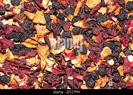 Hintergrund Textur duftenden trockenen schwarzen Tee mit Früchten und Blütenblättern. Tee mit einer Vorherrschaft von trockenen Himbeeren. Stockfoto