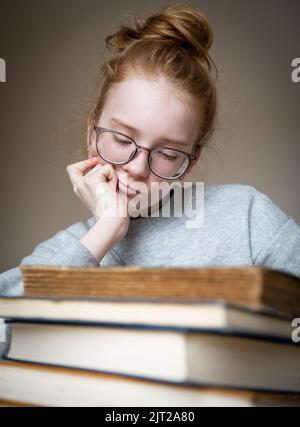 Porträt eines rothaarigen Teenagers mit Büchern. Stockfoto