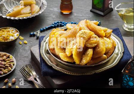 Arabische Küche; traditionelles Ramadan-Dessert 'Qatayef' oder Atayef'.Nahaufnahme für köstliches Ramadan-Dessert mit gerösteten Nüssen und Honigsirup. Stockfoto