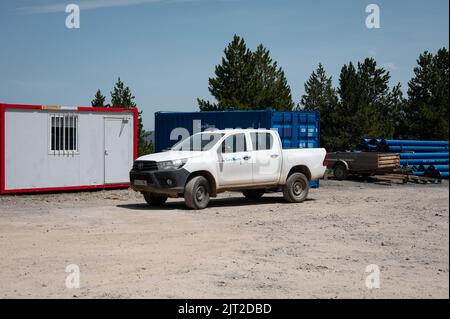 Ein weißer Toyota Hilux Pickup-Truck, der in einem Arbeitsbereich geparkt ist Stockfoto
