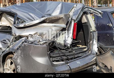 Hat während des Krieges in der Ukraine ein Auto erschossen. Ein Auto nach einem Unfall mit einer kaputten Heckscheibe. Das Wrack im Innenraum eines modernen Autos nach einem Unfall Stockfoto