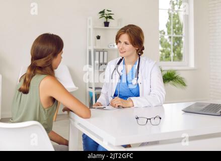 Arzt Kinderarzt im Gespräch mit einer Patientin im Teenageralter, die ihr von der medizinischen Versorgung im Krankenhaus erzählt. Stockfoto