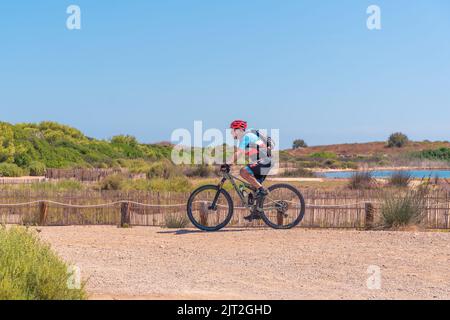 Älterer Mann, der mit dem Mountainbike unterwegs ist. Stockfoto