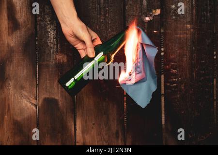 Molotow-Cocktail in den Händen eines Mädchens, Kriegsrecht in der Ukraine, ein Mädchen, das sich bereit macht, ihr Haus zu verteidigen, brennbares Gemisch in Flaschen mit einem Lappen, Stockfoto