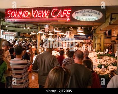 Seattle USA - Juli 20 2008; im Pyke Place berühmter Bauernmarkt Pyke Place Fischmarkttheke mit Menschen um die Ausstellung unter Sound View Cafe br Stockfoto