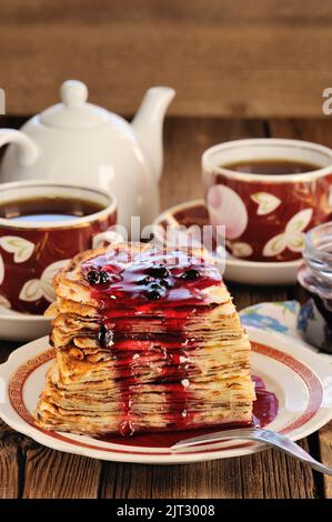 Russische Stinkesorte mit Johannisbeermarmelade, Teetassen, Kanne auf Holzhintergrund aus der Nähe Stockfoto