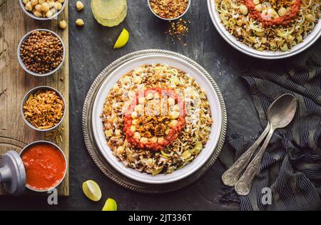 Arabische Küche; traditionelle ägyptische Küche: Köstlicher Reis aus Kushary oder Koushari, Nudeln, Kichererbsen, Linsen, knusprig gebratene Zwiebeln und frische Zitrone. Stockfoto