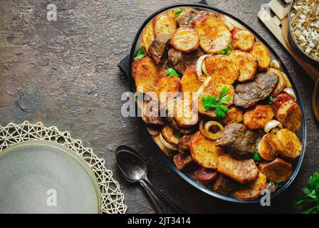 Arabische Küche; ägyptisch-orientalisches Gericht „gebackene Kartoffeln mit Kalbsstückchen“, serviert mit traditionellem Reis mit Vermicelli. Draufsicht mit Kopierbereich. Stockfoto