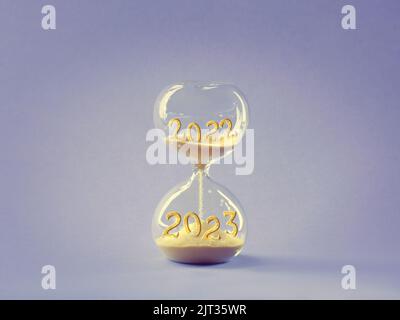 Sanduhr, Zeitverlauf von 2022 bis 2023 Jahre. Holz künstlerisches Modell Hand halten Zeit Glas. Countdown für die Winterferien. Frohe Weihnachten und ein Stockfoto