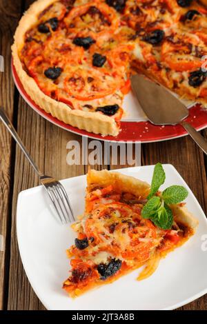 Tomatentorte mit Oliven auf Holzhintergrund Nahaufnahme Makro Stockfoto