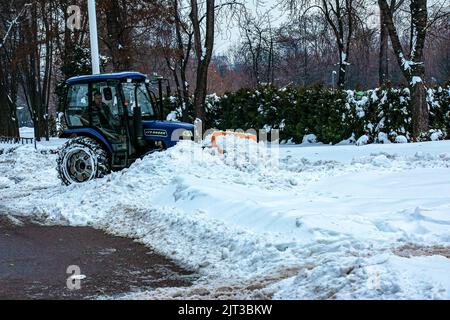 Dnepropetrovsk, Ukraine - 12.30.2021: Blauer Traktor reinigt Stadtstraßen und Straßen nach starkem Schneefall. Kommunale Dienste sind an der Schneeräumung beteiligt Stockfoto