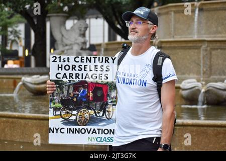 Die Teilnehmerin der Rallye hält vor dem Pulitzer-Brunnen in Manhattan Schilder zur Bekämpfung von Tiermissbrauch, um das Ende der Pferdekutschenmisshandlung in New York zu fordern Stockfoto