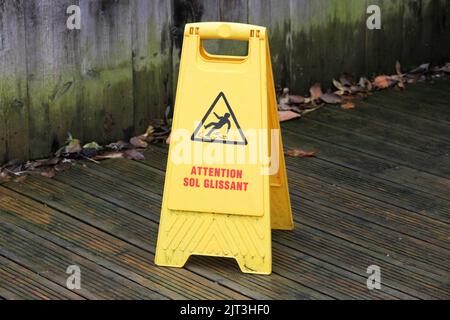 Vorsicht rutschige Bodenoberfläche Schild genannt Aufmerksamkeit sol glissant in französischer Sprache Stockfoto