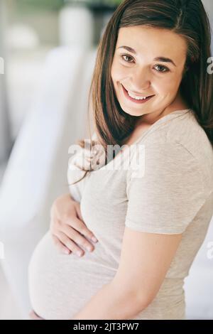 Ich kann es kaum erwarten, die kleine zu treffen, eine junge Frau, die mit ihrem schwanger Bauch posiert. Stockfoto