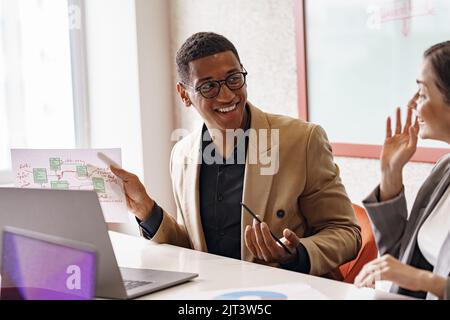 Lächelnde Coworker kooperieren und arbeiten zusammen im Coworking Space, Teamwork-Konzept Stockfoto