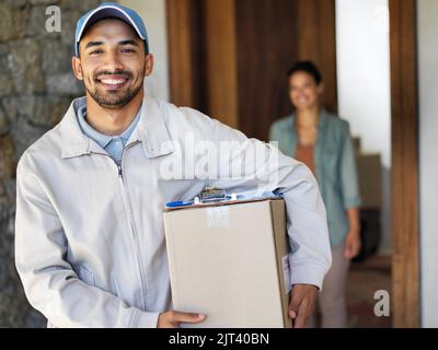 Wir heben die Expresslieferung auf eine neue Ebene. Porträt einer lächelnden jungen Kurierin, die ein Paket mit einem Kunden trägt, der an ihrer Eingangstür im steht Stockfoto