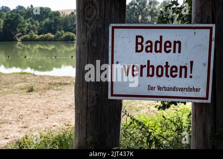 PRODUKTION - 26. August 2022, Niedersachsen, Reinhausen: Ein Schild 'Baden verboten!' Ist vor dem Badebereich am Wendebachstaussee im Landkreis Göttingen aufgestellt. Aufgrund von Ansammlungen toxischer Blaualgen hat das Gesundheitsministerium Warnungen für mehr als 30 Badestellen herausgegeben. Foto: Swen Pförtner/dpa Stockfoto