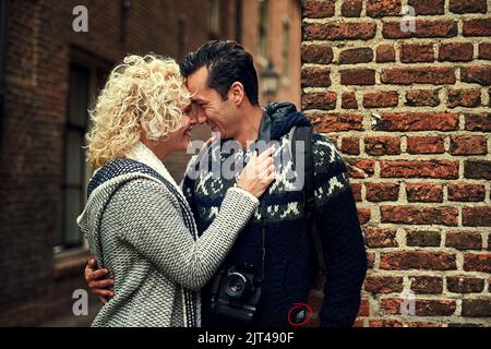 Sich in den Augen des anderen verirrt. Ein liebevolles junges Paar, das seine Zeit im Urlaub genießt. Stockfoto