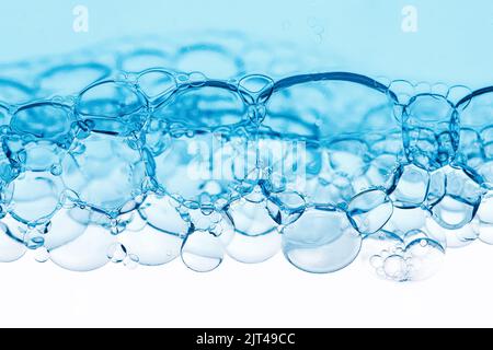 Transparente blaue Blasen in verschiedenen Größen auf weißem Hintergrund. Wissenschaftliches Hintergrundkonzept mit Textur aus Wasserstoff und vergrößerten Molekülen. Textur Stockfoto