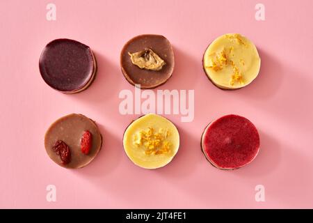 Sechs bunte, rohe vegane Dessets mit Goji, Zitrone, Heidelbeere, Himbeere und Banane Stockfoto