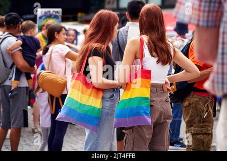 PRAG, TSCHECHISCHE REPUBLIK - 13. AUGUST 2022: LGBT-Frauen mit farbenfrohen Regenbogentaschen auf dem Wenzelsplatz während ihres schwulen Stolzes Stockfoto