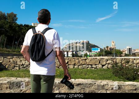 Ein älterer kaukasischer Tourist, der die Aussicht auf die Burg Santa Barbara in Alicante, Spanien, genießt Stockfoto