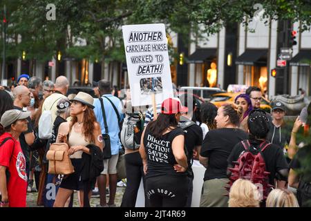 New York, New York, USA. 27. August 2022. Die Teilnehmerin der Rallye hält am 27. August 2022 vor dem Pulitzer Fountain in Manhattan ein Schild zur Bekämpfung von Tiermissbrauch, um die Beendigung des Kutschenmissbrauchs in New York City zu fordern. (Bild: © Ryan Rahman/Pacific Press via ZUMA Press Wire) Stockfoto