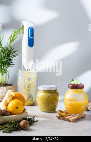 Mixer in einer Schüssel. Frisch zubereitete Marmelade aus Honig, Nüssen und Früchten. Ingwer, Honig und Zitrusmarmelade. Stockfoto