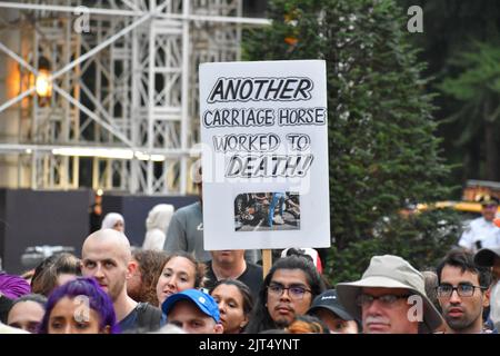 New York, New York, USA. 27. August 2022. Die Teilnehmerin der Rallye hält am 27. August 2022 vor dem Pulitzer Fountain in Manhattan ein Schild zur Bekämpfung von Tiermissbrauch, um die Beendigung des Kutschenmissbrauchs in New York City zu fordern. (Bild: © Ryan Rahman/Pacific Press via ZUMA Press Wire) Stockfoto