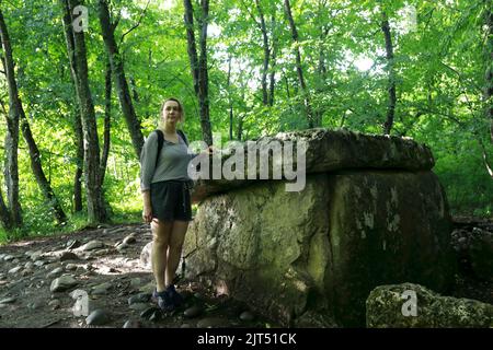 Frau, die im Sommer neben Dolmen posiert, Adygea Stockfoto