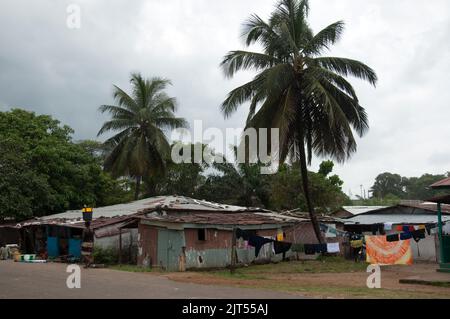 Blick auf die Straße, Sinkor, Monrovia, Liberia bedrohlicher Himmel der Regenzeit, Häuser, Waschen, Frau mit Eimern Stockfoto