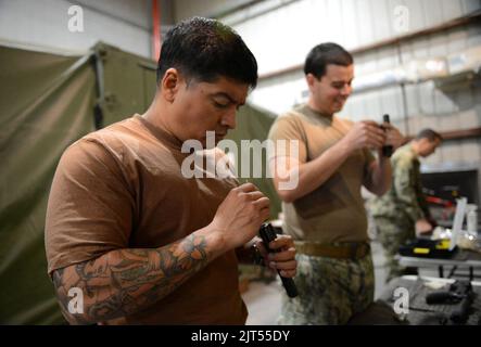 Die Mate 1. Class Left der US-Marine Boatswain und die Mineman 1. Class, die beide Commander, Task Force (CTF) 56, zugewiesen wurden, reinigen M4 Karabinerbolzen während des Waffentrainings bei Naval 140212 Stockfoto