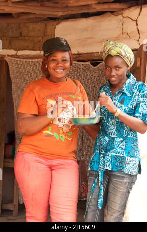 Junge Damen genießen ihr Mittagessen, Gbanga Market, Gbanga, Lofa County, Liberia, Afrika. Gbanga ist eine kleine Stadt an der Hauptstraße nördlich in Liberia. Stockfoto