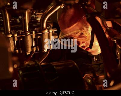 US Navy Gas Turbine System Technician (Mechanical) 3. Class führt routinemäßige Wartungsarbeiten an einem Motor an Bord des Lenkflugkörperzerstörers USS Sterett (DDG 104) durch, während er an Operation 141018 teilnimmt Stockfoto