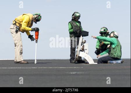 U.S. Navy LT. Links, Aviation Boatswain's Mate (Equipment) Airman Center und Aviation Boatswain's Mates (Equipment) 3. Class and Perform Katapult 140219 Stockfoto