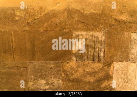 Detailansicht einer mittelalterlichen massiven Sandsteinmauer eines Burgturms als Hintergrund Stockfoto