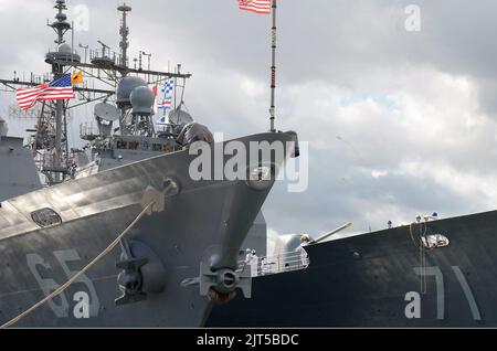 US-Matrosen an Bord des Lenkrakenkreuzers USS Cape St. George (CG 71), rechts, werfen die Anlegestellen an Besatzungsmitglieder an Bord des Lenkrakenkreuzers USS Chosin (CG 65), als das Schiff an der Joint Base Pearl 140625 ankommt Stockfoto