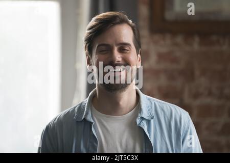 Glücklicher selbstbewusster Mann im legeren Denim-Hemd, der die Kamera anschaut Stockfoto