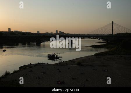 Warschau, Polen. 26. August 2022. Die Sonne scheint über der Skyline der Stadt, während am 26. August 2022 ein Ponton auf der Weichsel in Warschau, Polen, zu sehen ist. Obwohl die Durchschnittstemperatur in Polen im August in den letzten Wochen etwas über 19 Grad Celsius beträgt, haben die Temperaturen täglich Höchststände von mehr als 30 Grad erreicht. (Foto von Jaap Arriens/Sipa USA) Quelle: SIPA USA/Alamy Live News Stockfoto