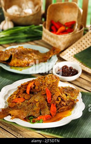 Pindang Ikan Nila, sundanesisches traditionelles Menü aus West-Java-Indonesien, hergestellt aus gebratenen Tilapia-Fischen mit Chili. Serviert auf weißem Teller Stockfoto