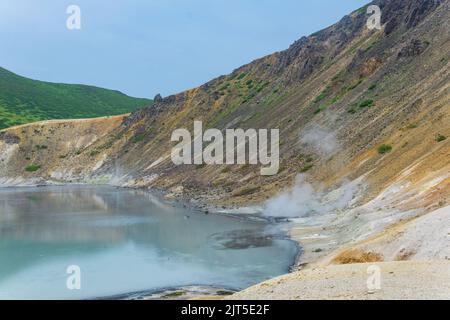 Vulkanische Landschaft, Fumarole Verdunstung am Ufer eines thermisch heiß mineralisierten Sees am Boden der Golovnin Vulkankaldera auf der Kunashir Isla Stockfoto