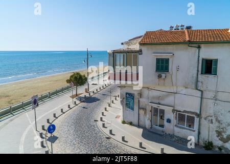 Larnaca, Zypern - 22. April 2022 - Häuser vor dem Finikoudes Strand im Zentrum von Larnaca im Sommer unter blauem Himmel Stockfoto